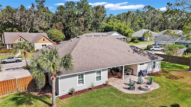 back of property featuring a fire pit, a lawn, and a patio