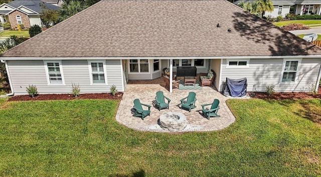 back of house featuring a lawn, an outdoor fire pit, and a patio area