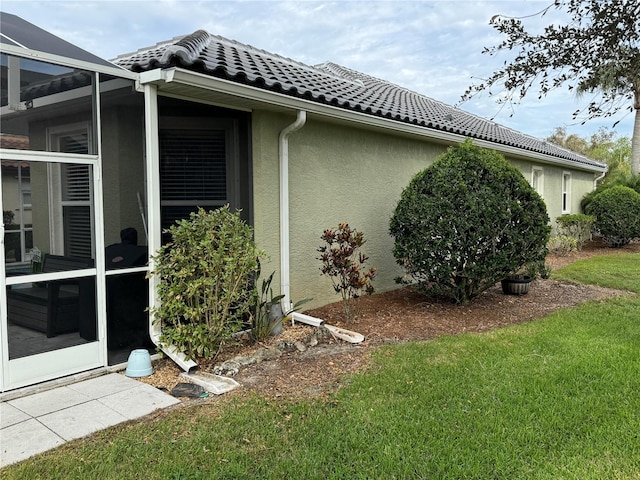 view of home's exterior featuring a lanai and a lawn