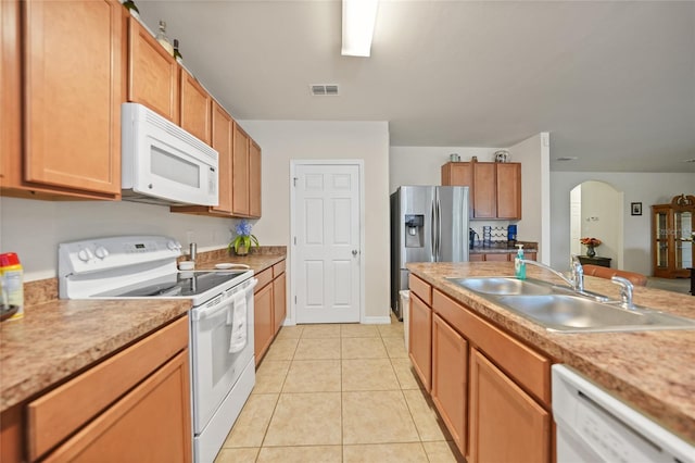 kitchen with sink, white appliances, and light tile patterned floors