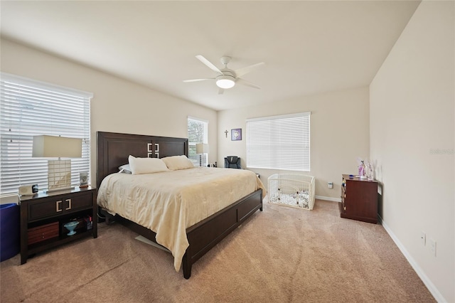 carpeted bedroom with multiple windows and ceiling fan