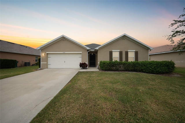 ranch-style house featuring central AC, a garage, and a yard