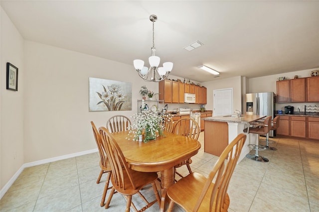 tiled dining room featuring sink and an inviting chandelier