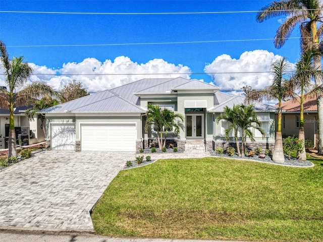 view of front of home featuring a front yard, a garage, and french doors