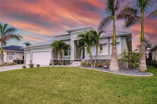 view of front of property featuring a garage and a lawn