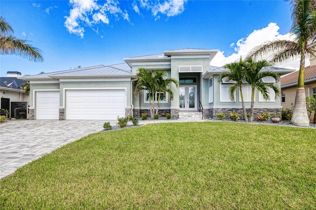 view of front of home featuring a front lawn, a garage, and french doors