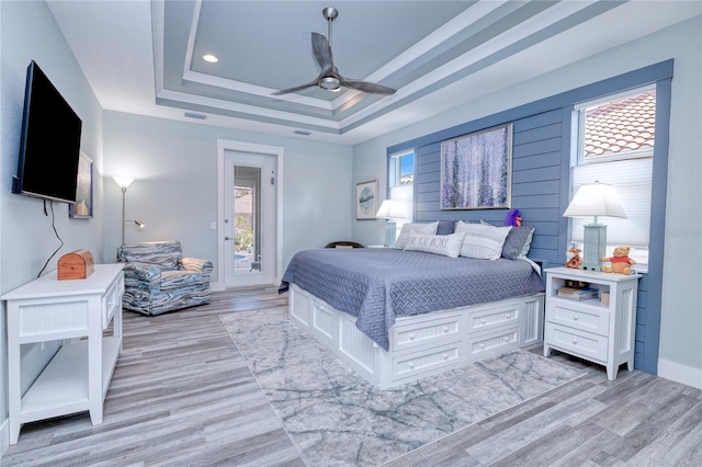 bedroom with ceiling fan, multiple windows, and light hardwood / wood-style floors