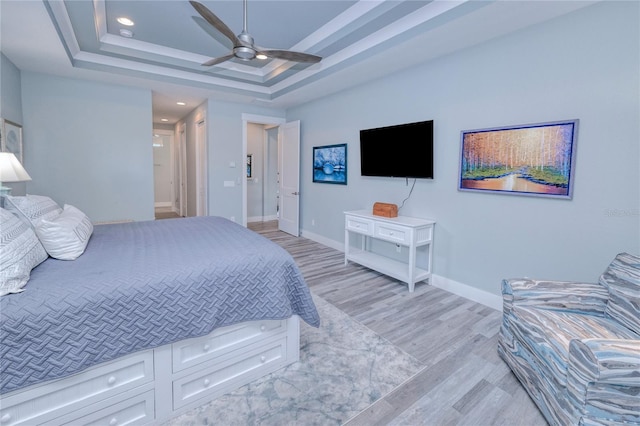 bedroom featuring a tray ceiling, ceiling fan, and light hardwood / wood-style floors