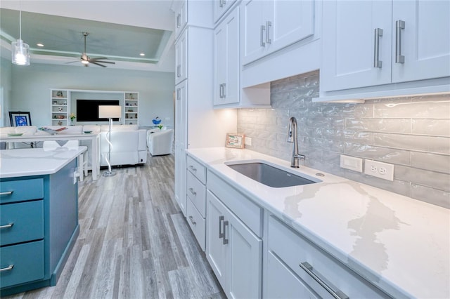 1450 Kiwi Ct, Punta Gorda, FL 33950 - kitchen with a sink, light wood finished floors, ceiling fan, backsplash, and a raised ceiling