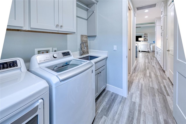 1450 Kiwi Ct, Punta Gorda, FL 33950 - laundry room featuring cabinet space, independent washer and dryer, light wood-style flooring, baseboards, and recessed lighting