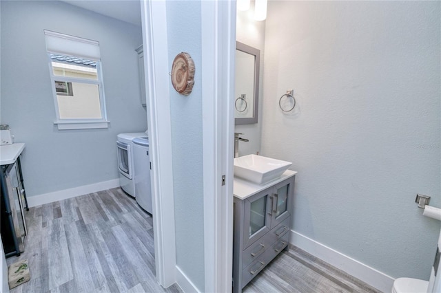 1450 Kiwi Ct, Punta Gorda, FL 33950 - bathroom featuring washing machine and dryer, vanity, wood finished floors, and toilet