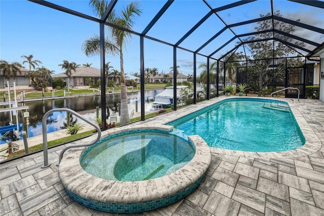 view of pool featuring an in ground hot tub, a patio, a water view, and glass enclosure