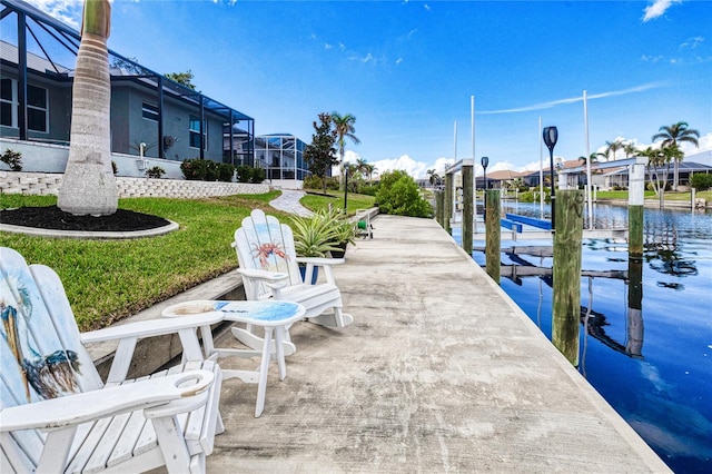 view of dock featuring glass enclosure, a yard, and a water view