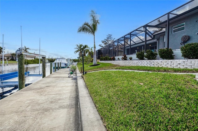 dock area featuring a water view, a yard, and a lanai