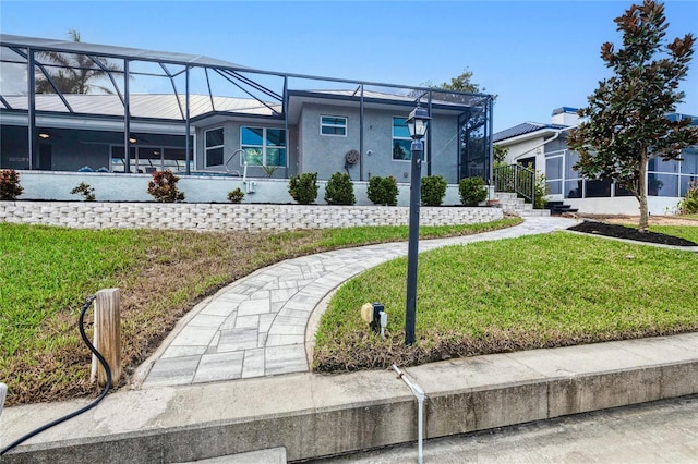 view of front of home featuring a front lawn and a lanai