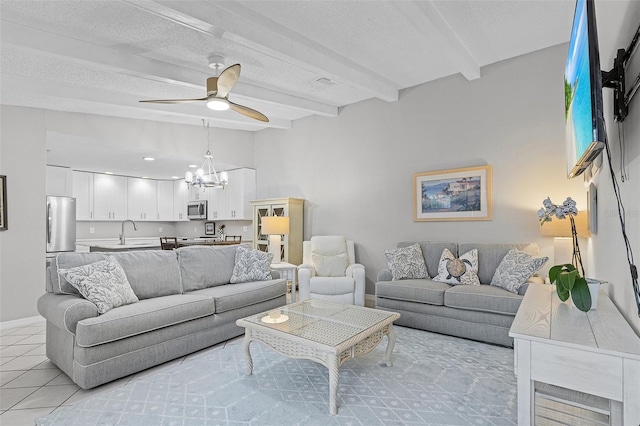 tiled living room featuring a textured ceiling, sink, ceiling fan with notable chandelier, and beam ceiling