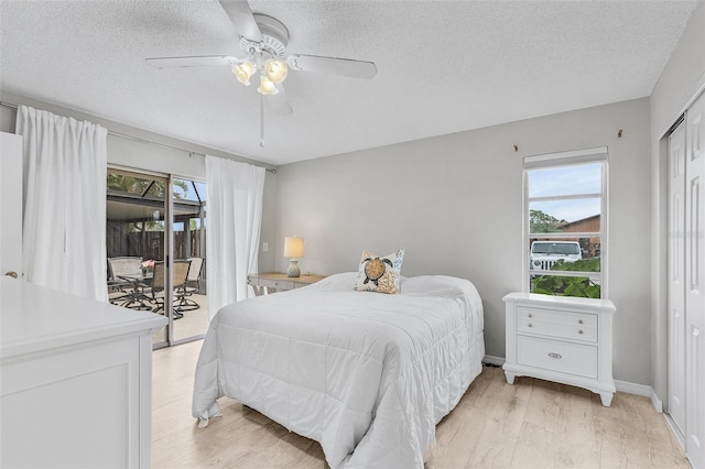 bedroom featuring access to exterior, a textured ceiling, ceiling fan, a closet, and light hardwood / wood-style flooring