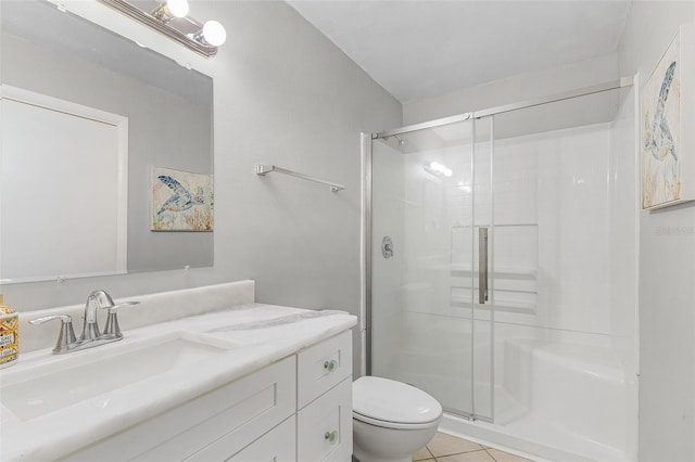 bathroom featuring toilet, vanity, tile patterned flooring, and a shower with shower door