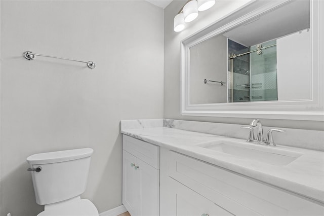 bathroom with an enclosed shower, vanity, and toilet