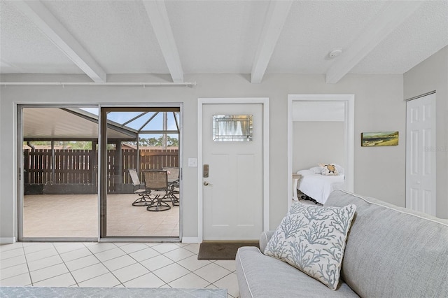 foyer entrance featuring a textured ceiling, beamed ceiling, and light tile patterned floors