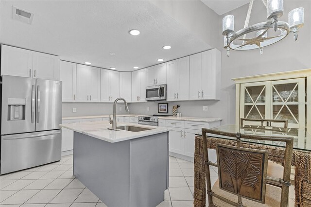 kitchen with white cabinets, sink, light tile patterned flooring, and stainless steel appliances