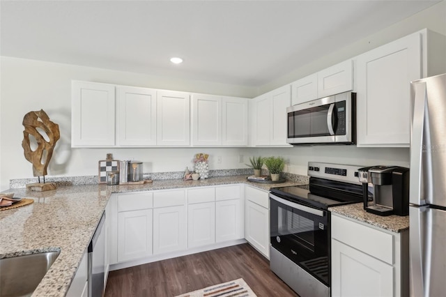 16307 Alcira Cir, Punta Gorda, FL 33955 - kitchen featuring appliances with stainless steel finishes, white cabinets, recessed lighting, dark wood-style floors, and light stone counters