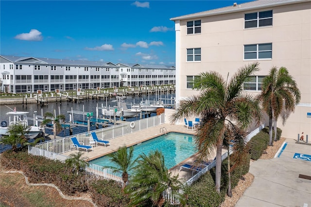 view of pool featuring a water view, a boat dock, and a patio area