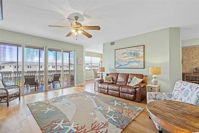 living room with ceiling fan and light hardwood / wood-style flooring