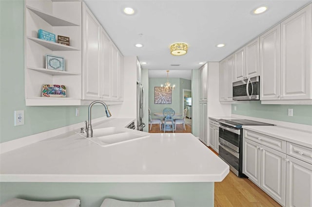 268 Lewis Cir Unit 132, Punta Gorda, FL 33950 - kitchen featuring appliances with stainless steel finishes, a chandelier, open shelves, a breakfast bar, and recessed lighting