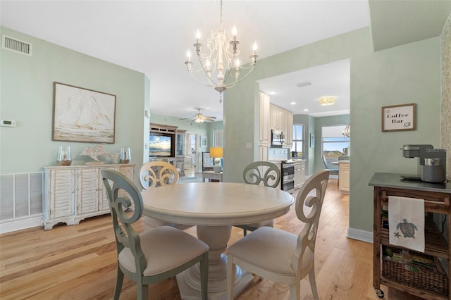 dining room featuring light hardwood / wood-style floors and ceiling fan with notable chandelier