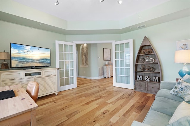 living room featuring french doors and light hardwood / wood-style floors