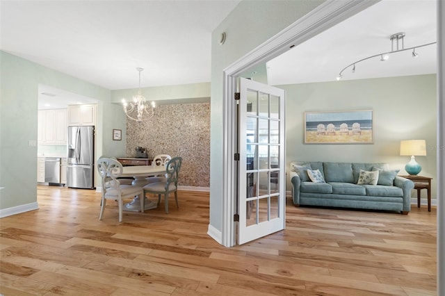 interior space with a notable chandelier and light hardwood / wood-style flooring