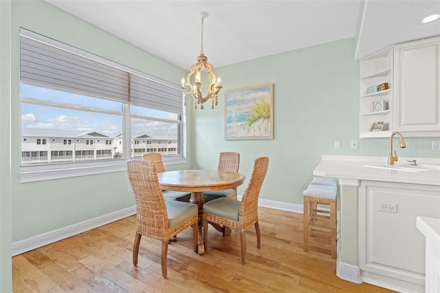 dining room featuring light hardwood / wood-style flooring, sink, and an inviting chandelier