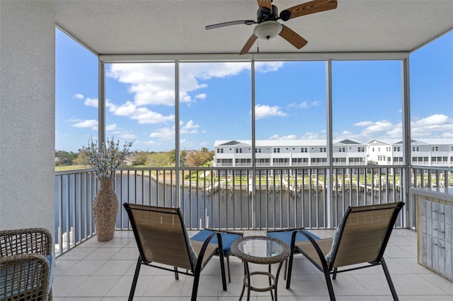 sunroom / solarium featuring plenty of natural light, a water view, and ceiling fan