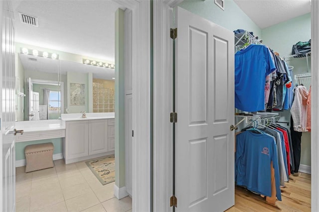 interior space with vanity, a textured ceiling, and tile patterned flooring