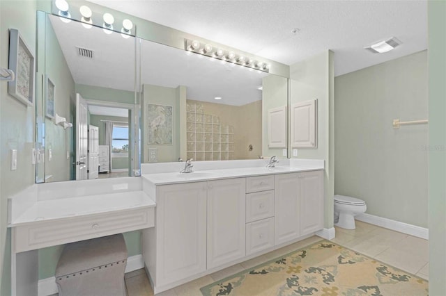 bathroom featuring toilet, vanity, a textured ceiling, and tile patterned flooring