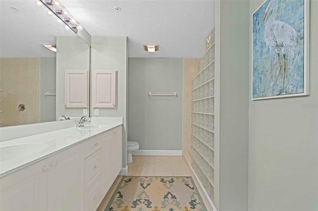 bathroom with toilet, tile patterned flooring, a textured ceiling, vanity, and a shower