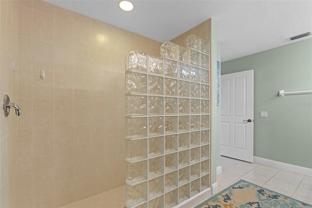 bathroom featuring tile patterned floors, a textured ceiling, and tiled shower