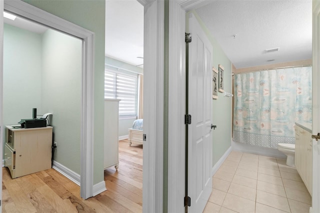 bathroom with toilet, shower / bath combo, a textured ceiling, and hardwood / wood-style flooring