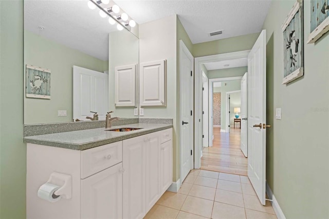 bathroom with hardwood / wood-style floors, a textured ceiling, and vanity