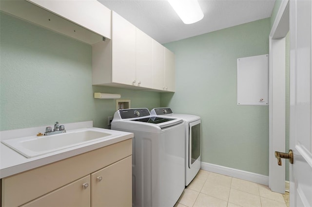 washroom with washer and clothes dryer, cabinets, sink, and light tile patterned flooring