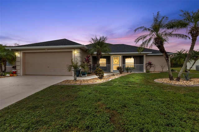 single story home featuring a garage, a porch, and a lawn