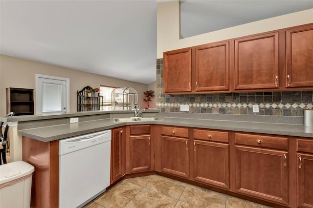 kitchen featuring white dishwasher, sink, kitchen peninsula, and tasteful backsplash