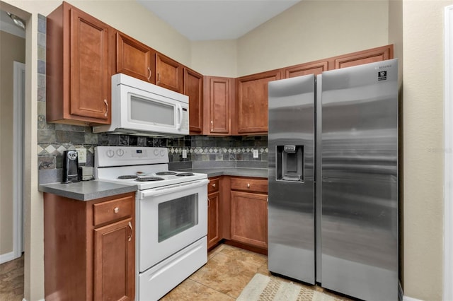 kitchen with white appliances, light tile patterned floors, and backsplash