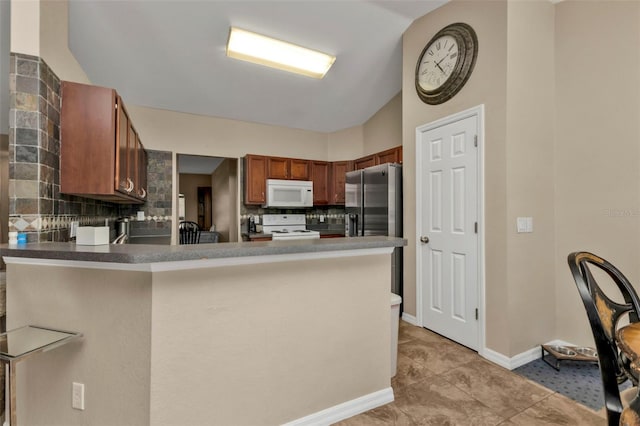 kitchen featuring kitchen peninsula, light tile patterned floors, white appliances, and backsplash