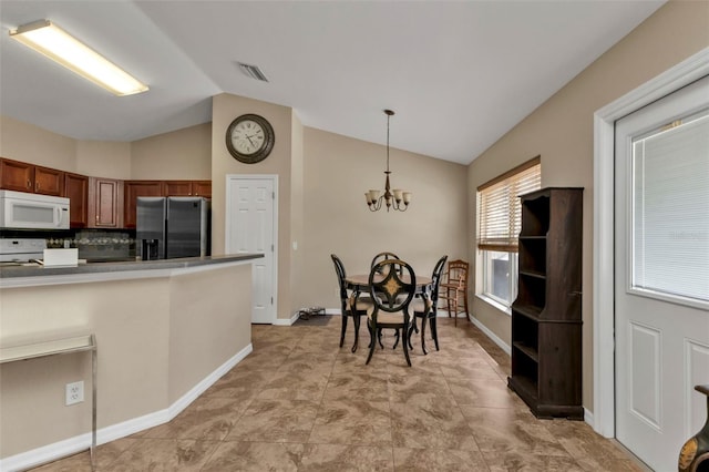 kitchen featuring tasteful backsplash, white appliances, a chandelier, pendant lighting, and vaulted ceiling