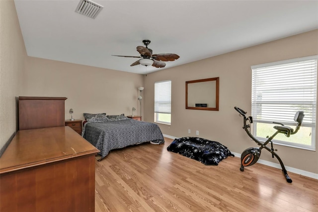 bedroom with light wood-type flooring, multiple windows, and ceiling fan