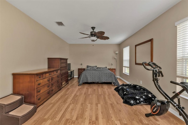 bedroom featuring ceiling fan, multiple windows, and light wood-type flooring