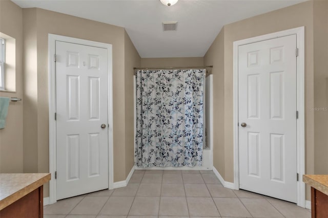 bathroom with vanity, shower / bath combination with curtain, and tile patterned floors