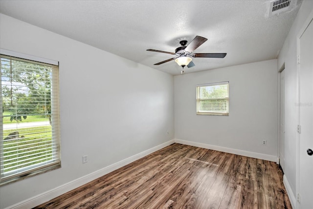 spare room with a textured ceiling, hardwood / wood-style flooring, and ceiling fan